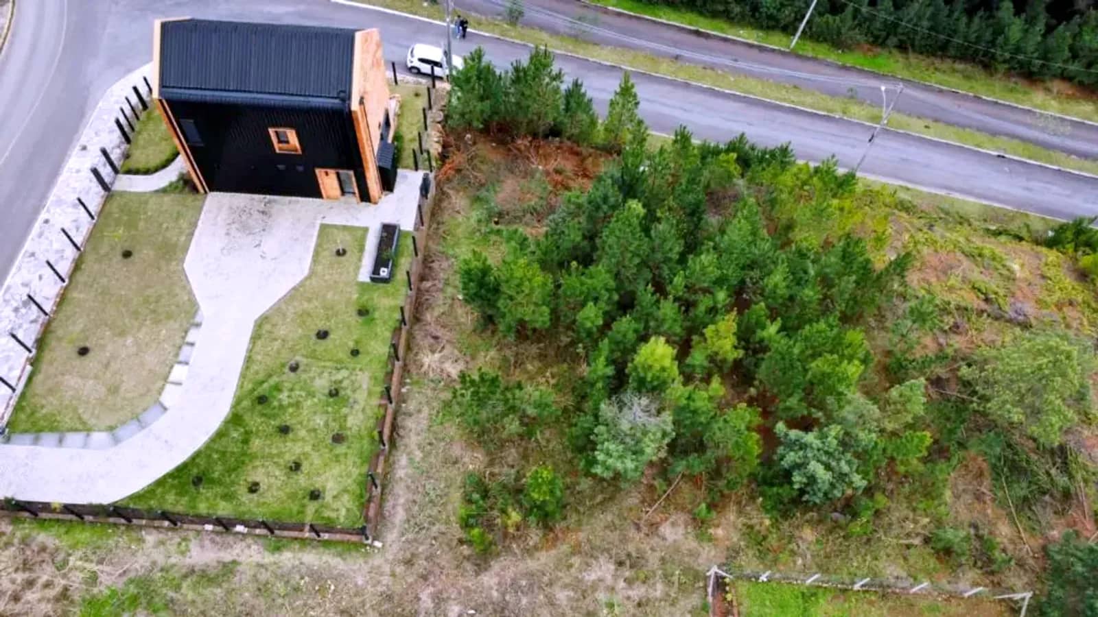 Terreno de 450 m² visto do alto, com a casa vizinha