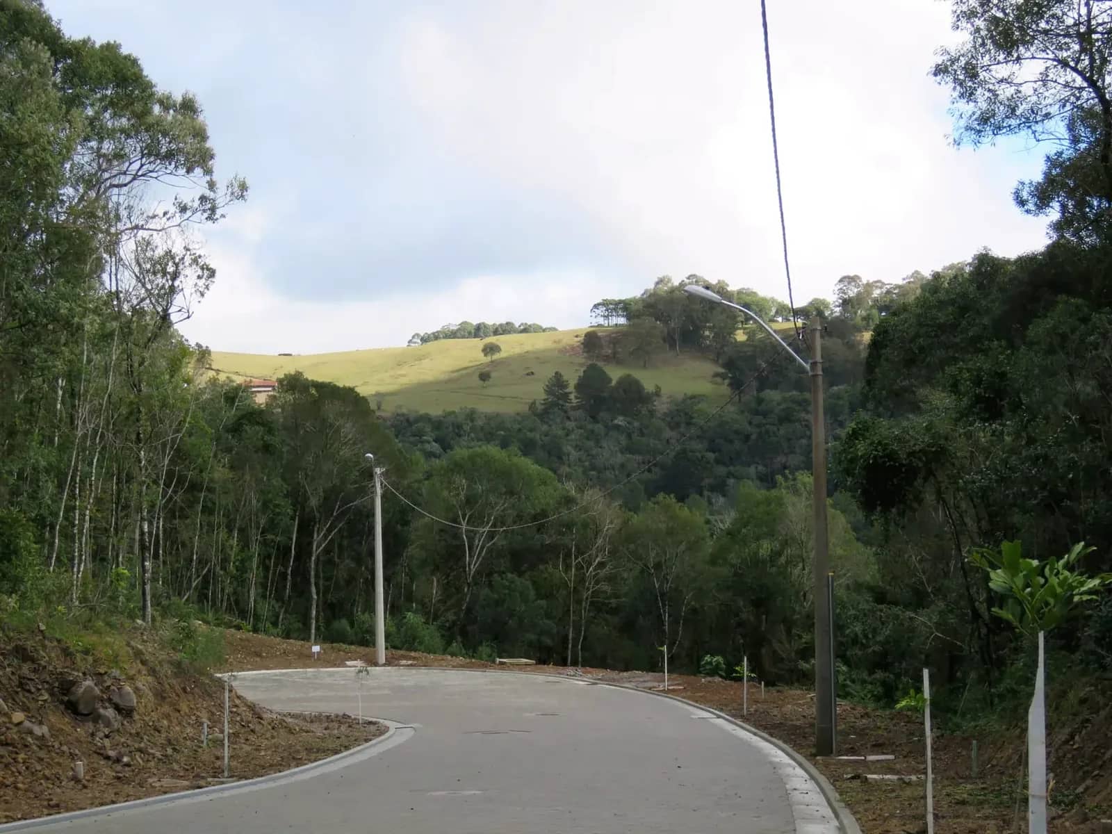 Rua calçada do loteamento no Pórtico II, em Gramado, com o vale ao fundo