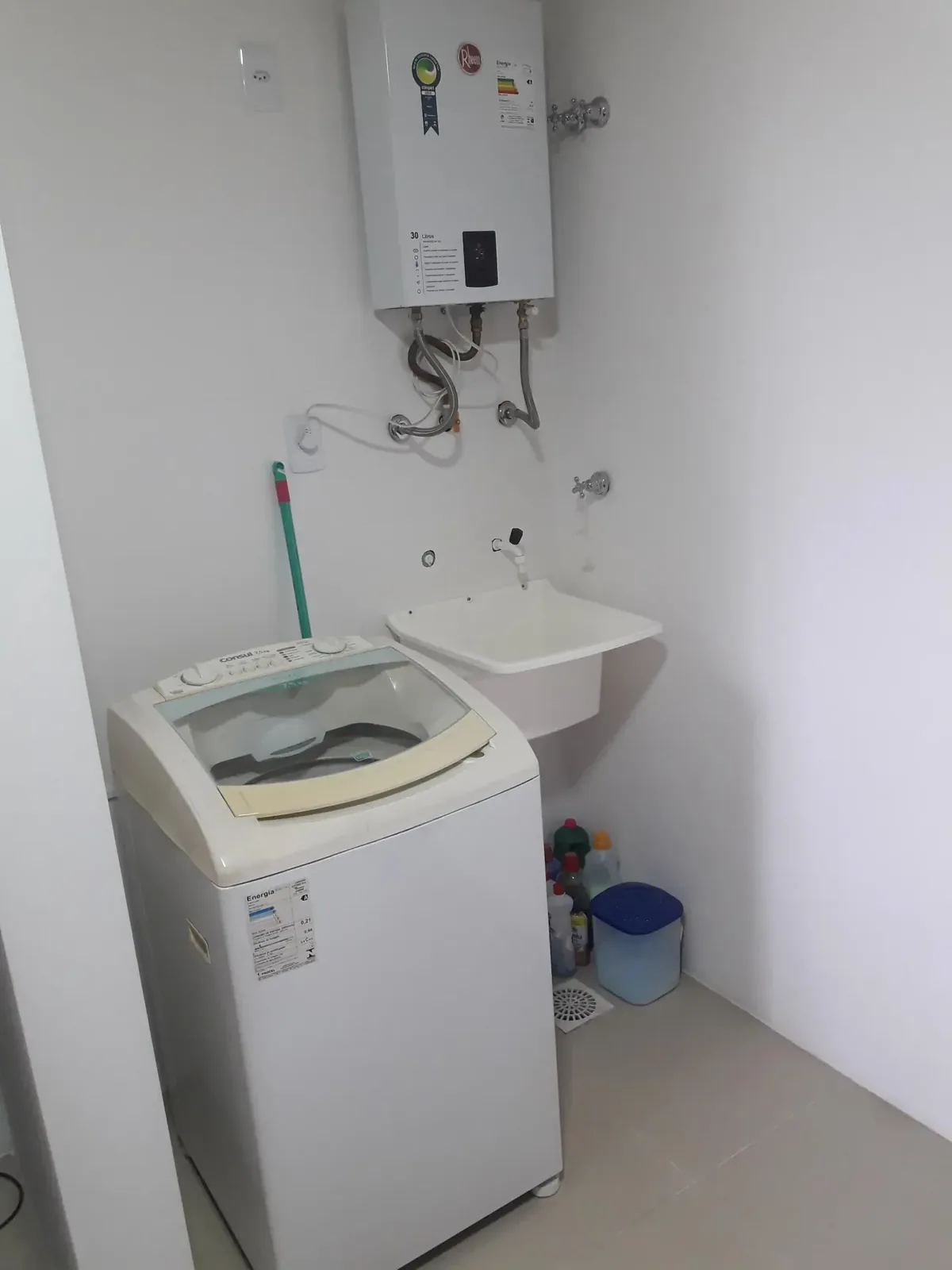 Área de serviço com máquina de lavar, tanque e aquecedor de água a gás