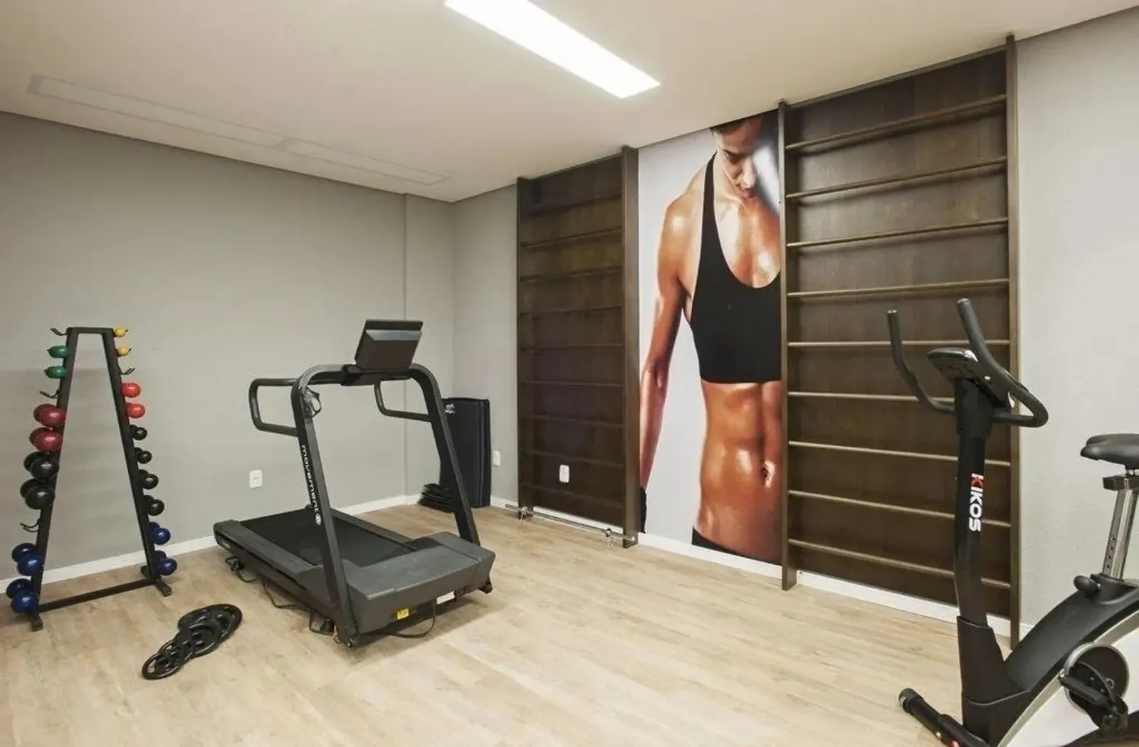 Academia do prédio com esteira, bicicleta e halteres