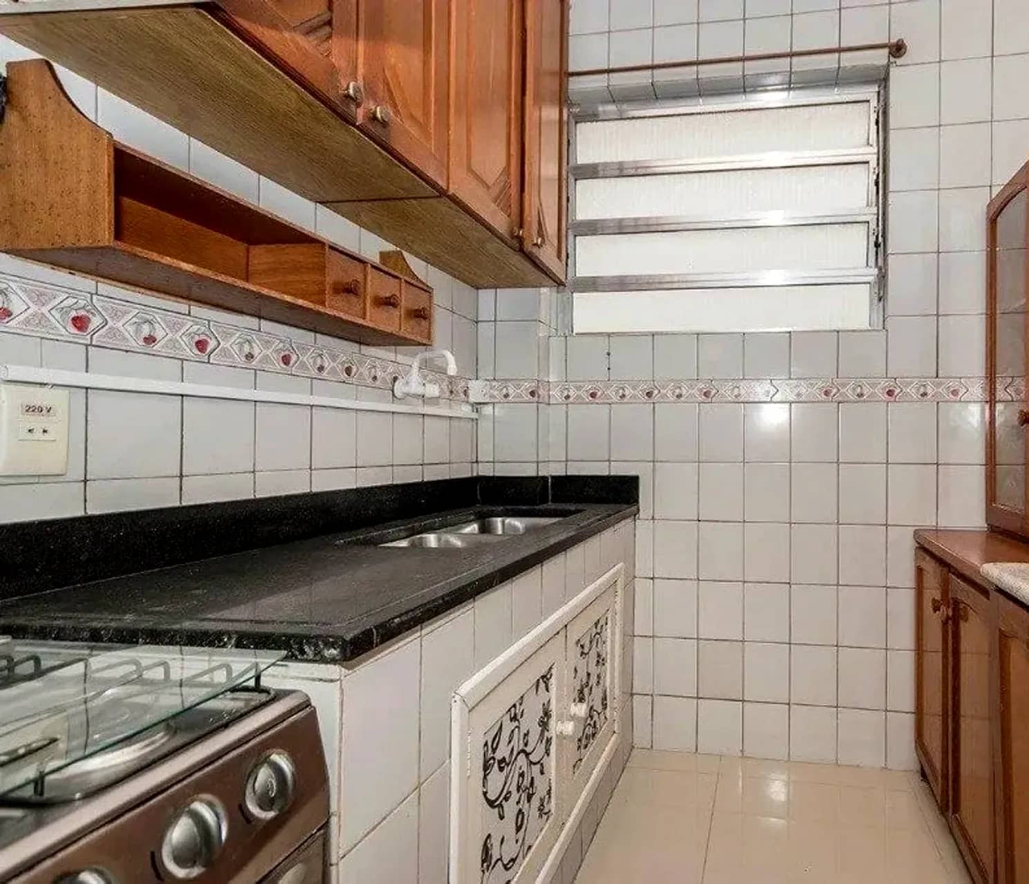 Cozinha com bancada de granito e armários de madeira