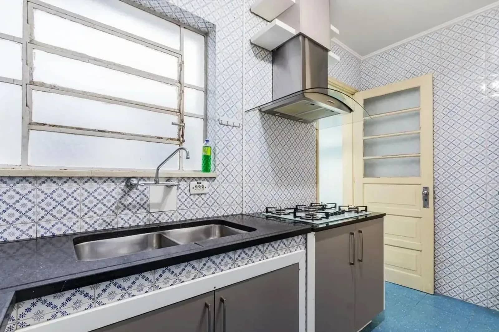 Cozinha com cooktop, coifa e bancada de granito