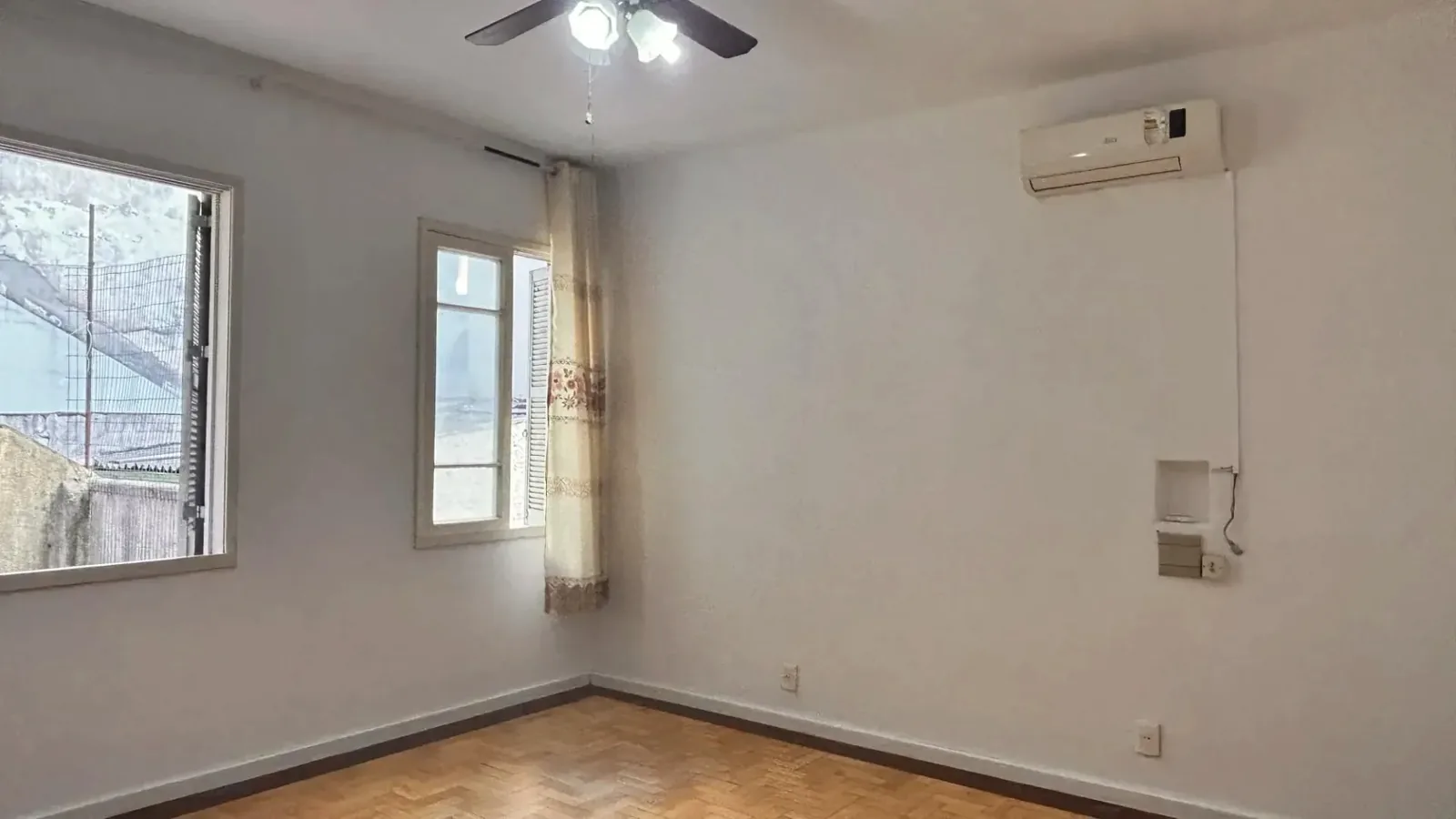 Dormitório com ar-condicionado e duas janelas