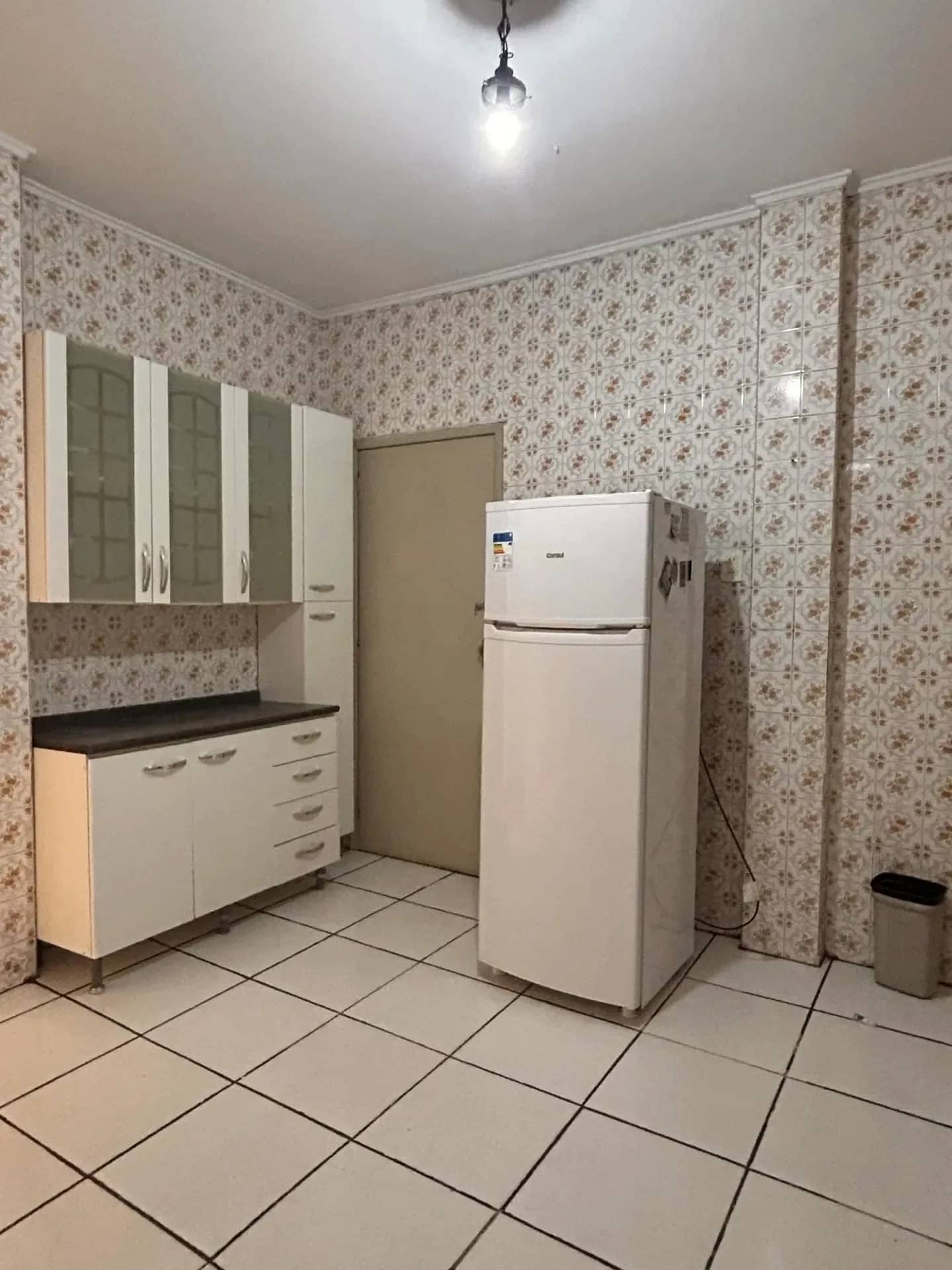 Cozinha com espaço para geladeira e armários