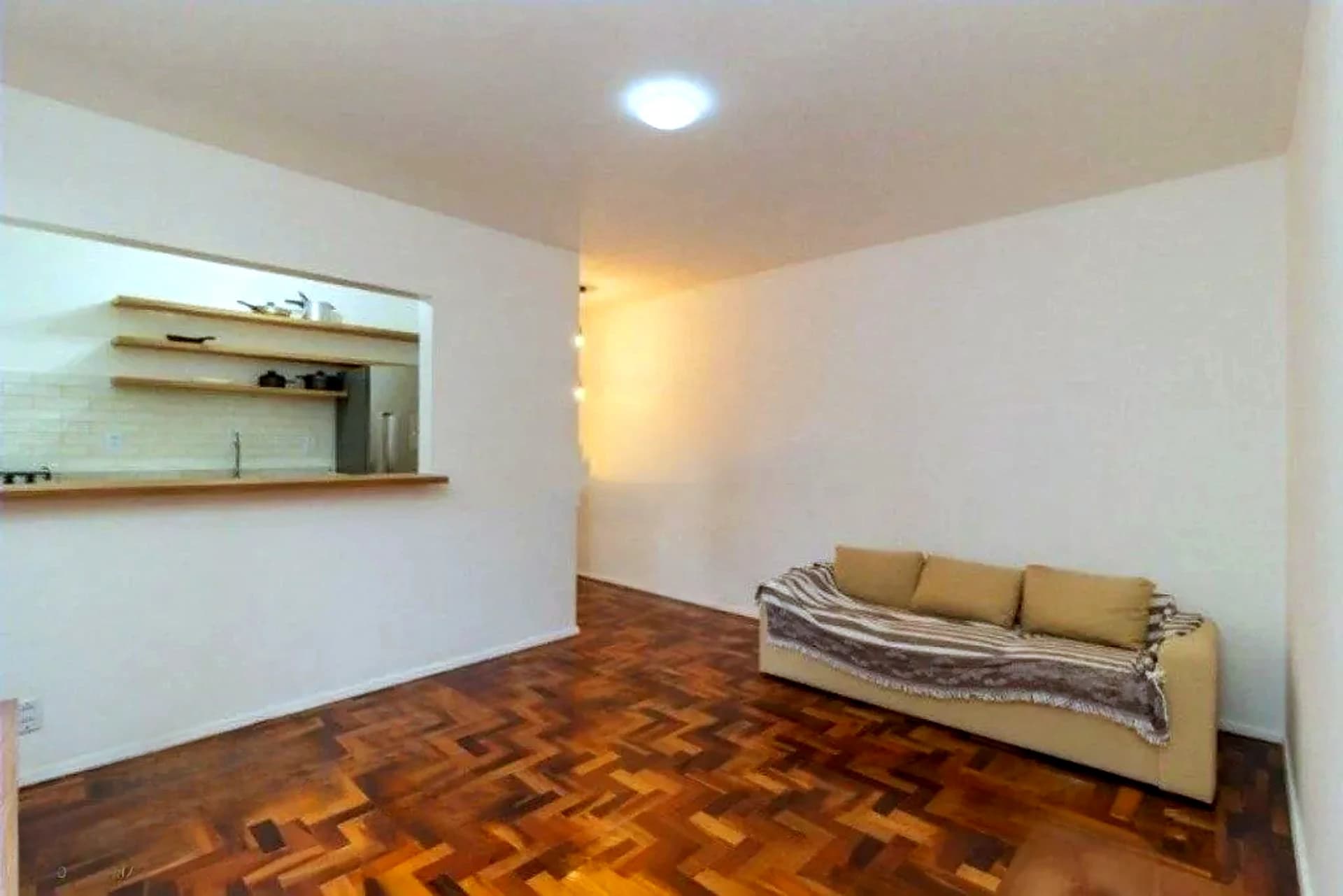 Sala ampla com piso de parquet e passa-pratos