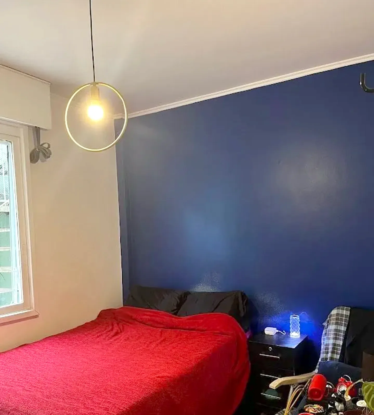 Dormitório com parede azul e luminária pendente