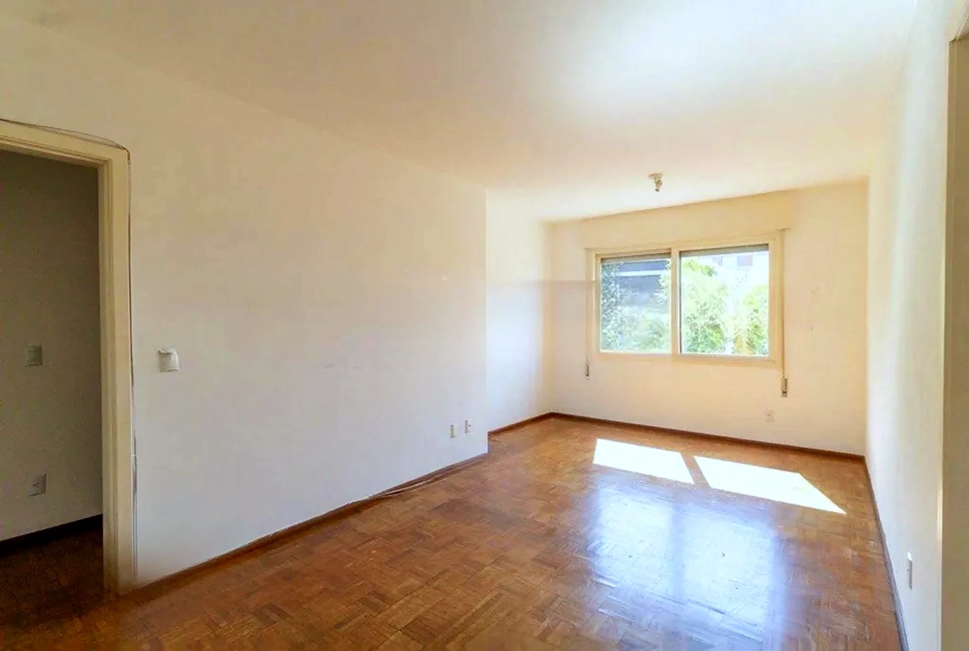 Dormitório com janela e parquet