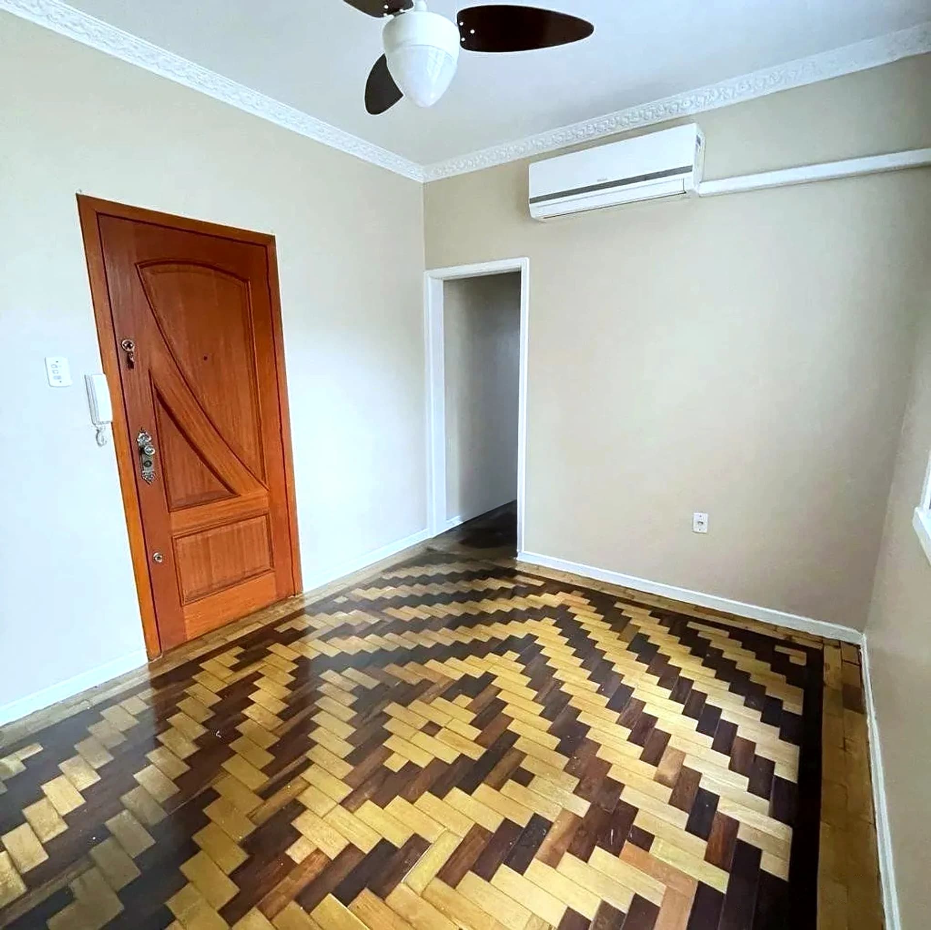 Sala com piso de parquet e porta de entrada