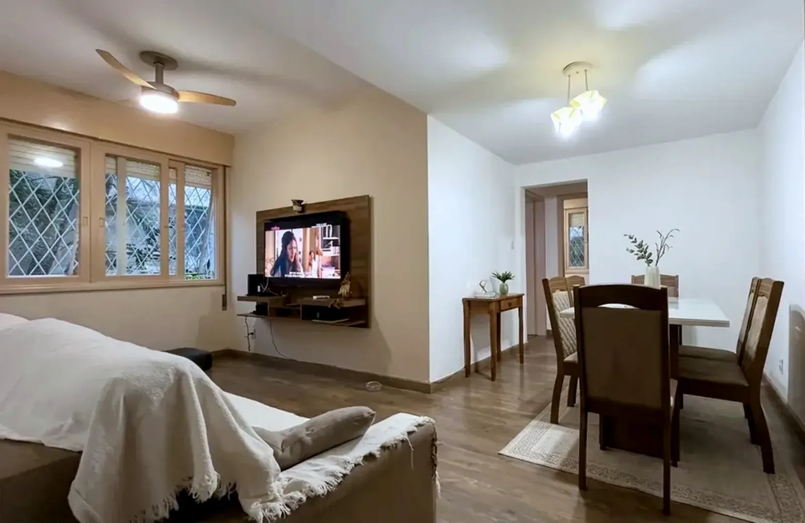 Living com piso de madeira e sala de jantar