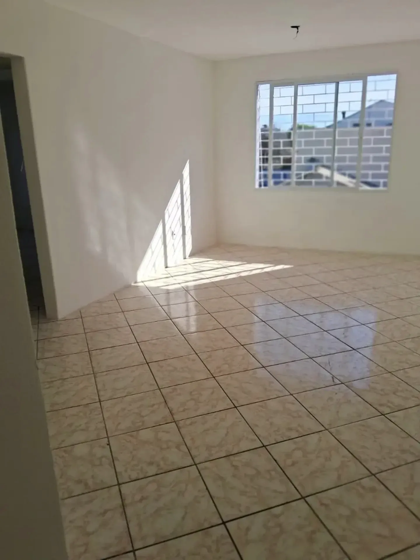 Living com piso claro e sol pela janela na Tristeza, em Porto Alegre