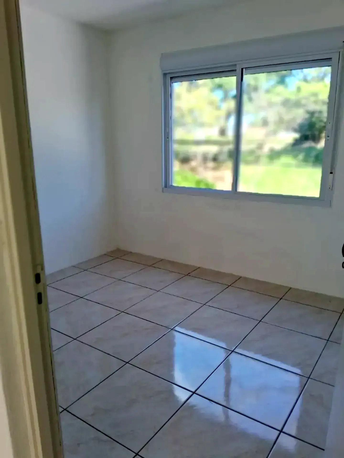 Dormitório com janela ampla e vista para o verde