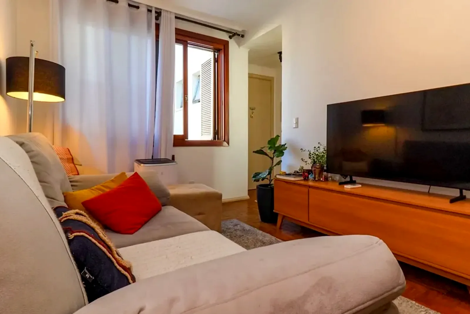 Sala de estar do apartamento na Auxiliadora, com piso de madeira