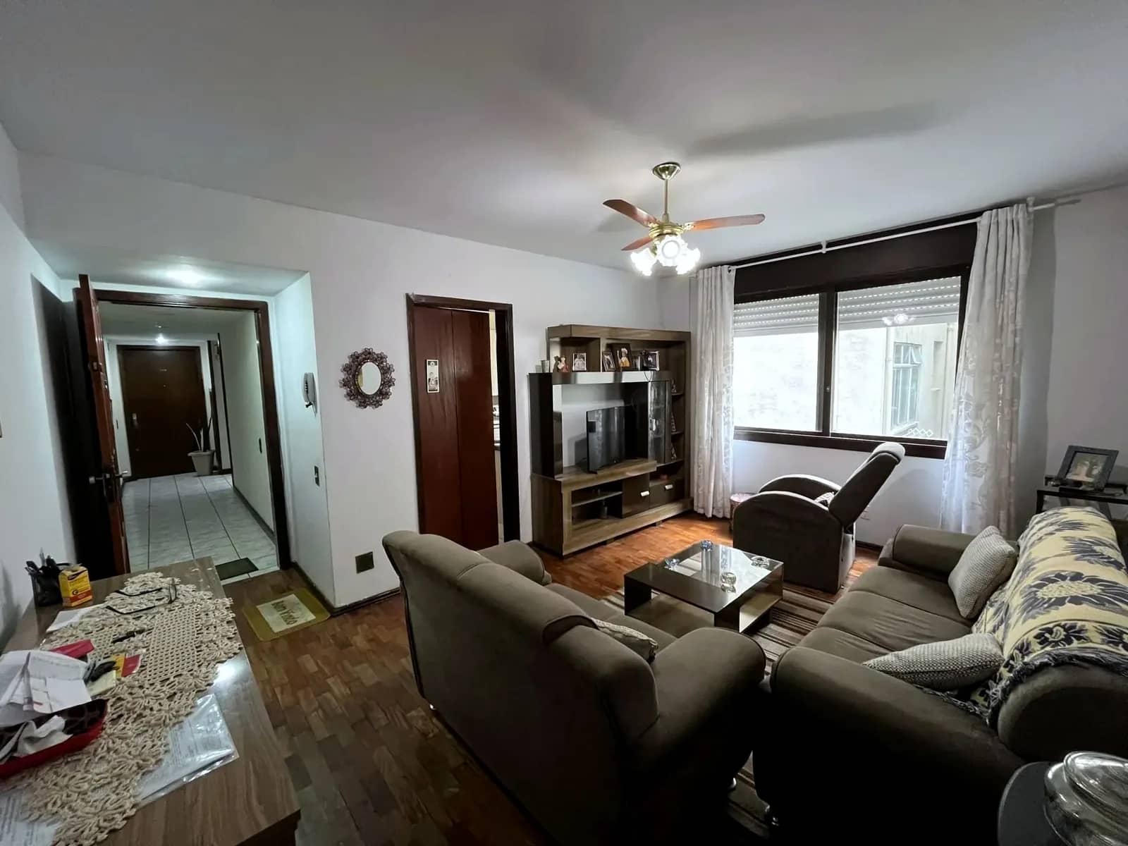 Living com janela ampla e acesso ao corredor