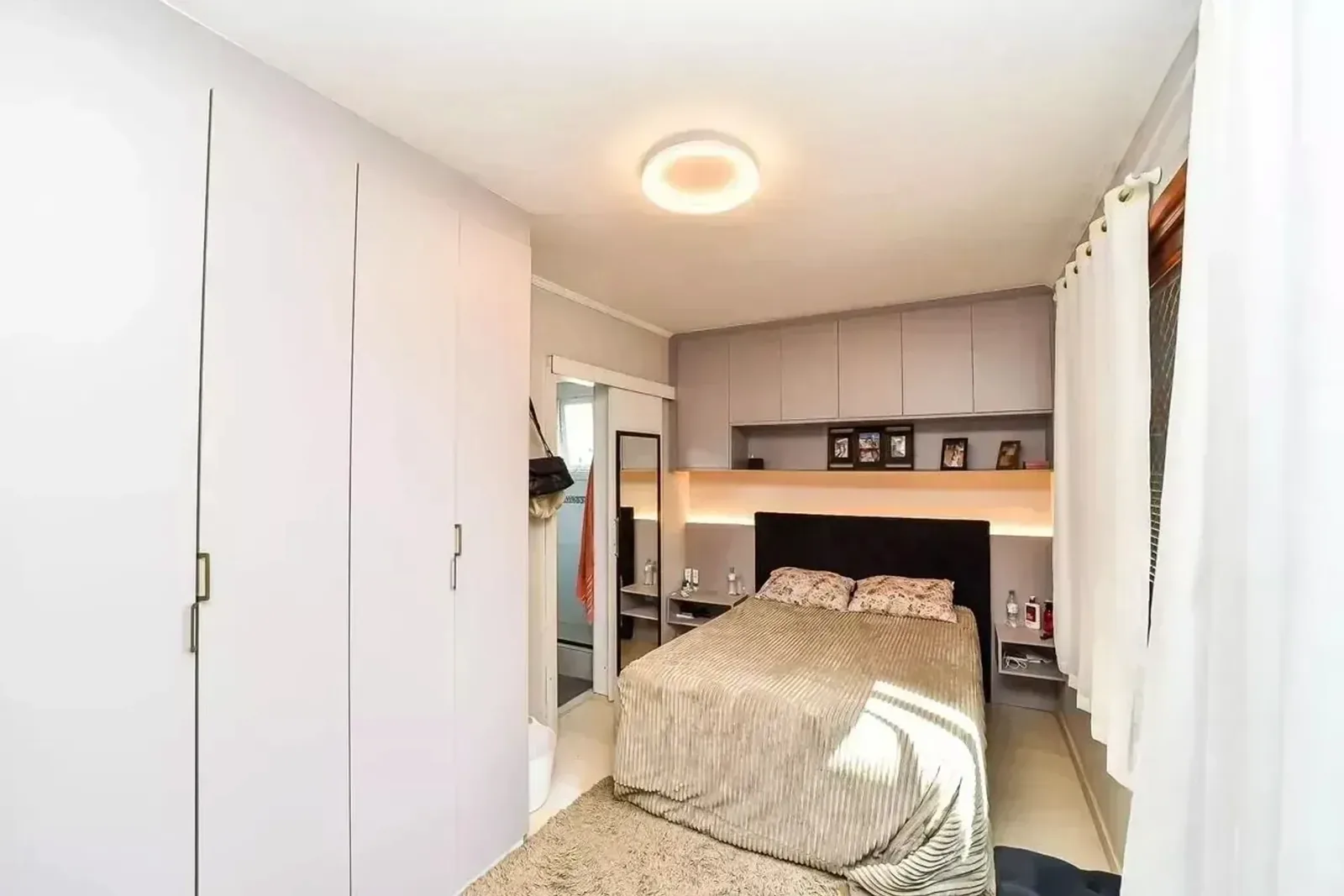 Suíte com cama de casal e iluminação embutida
