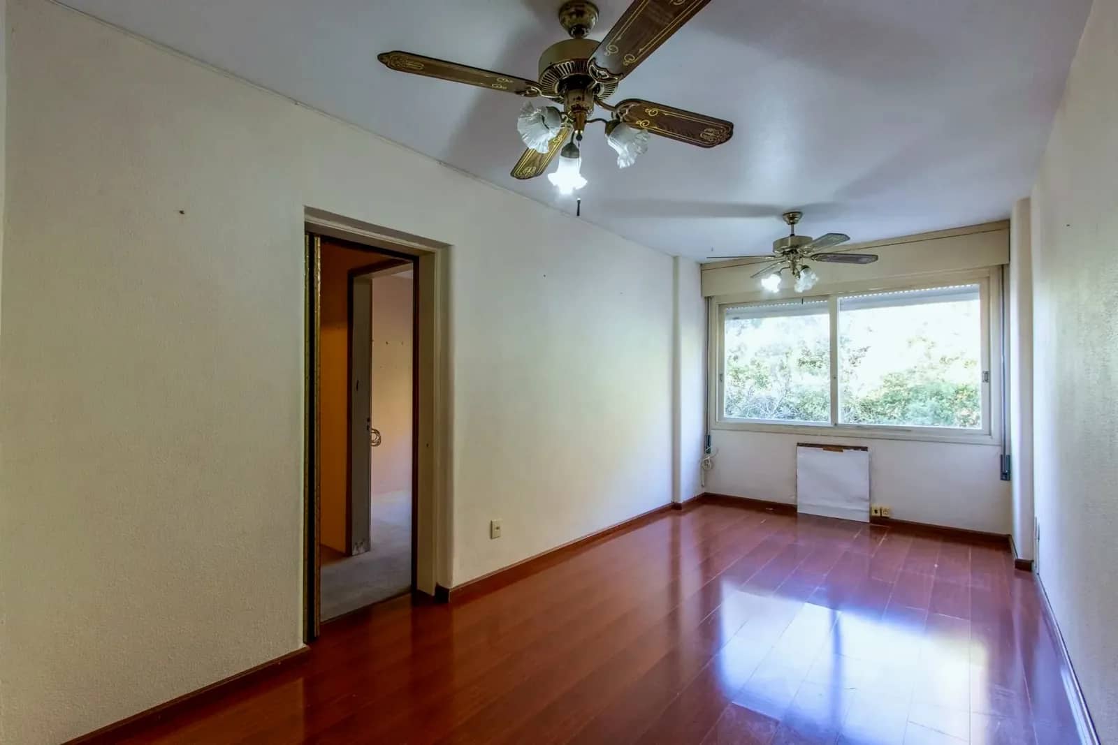 Living com piso laminado e janela ampla