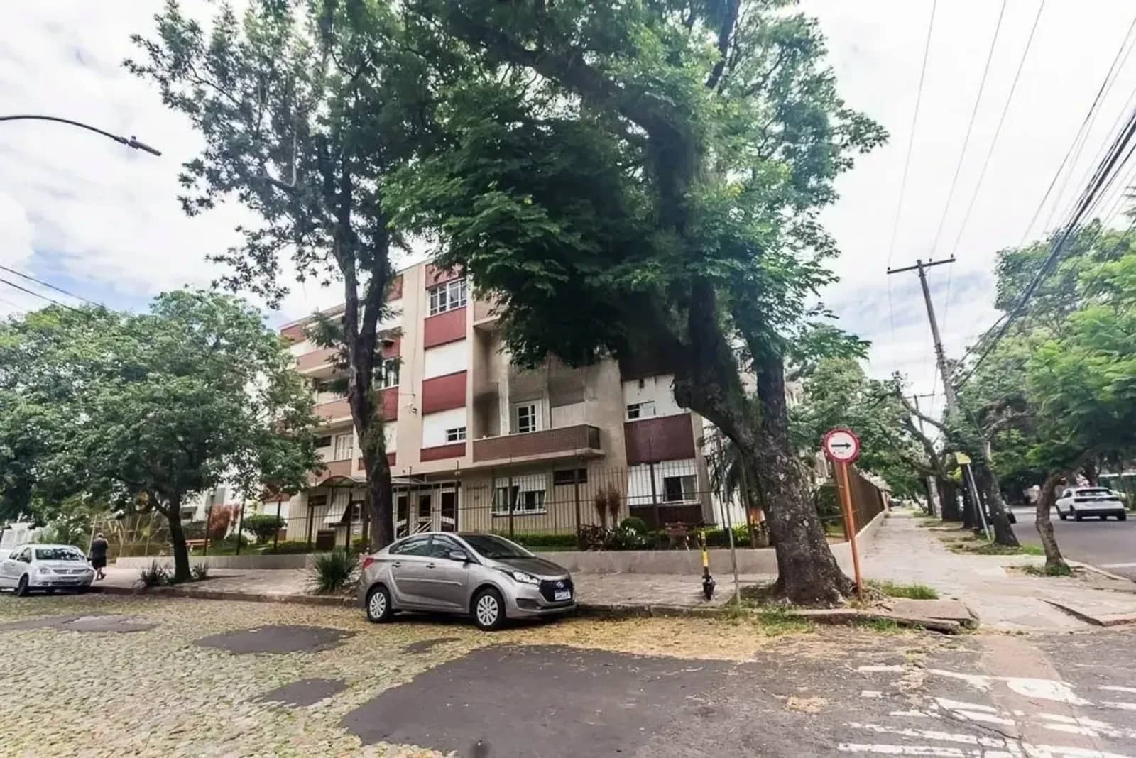 Rua arborizada em frente ao prédio