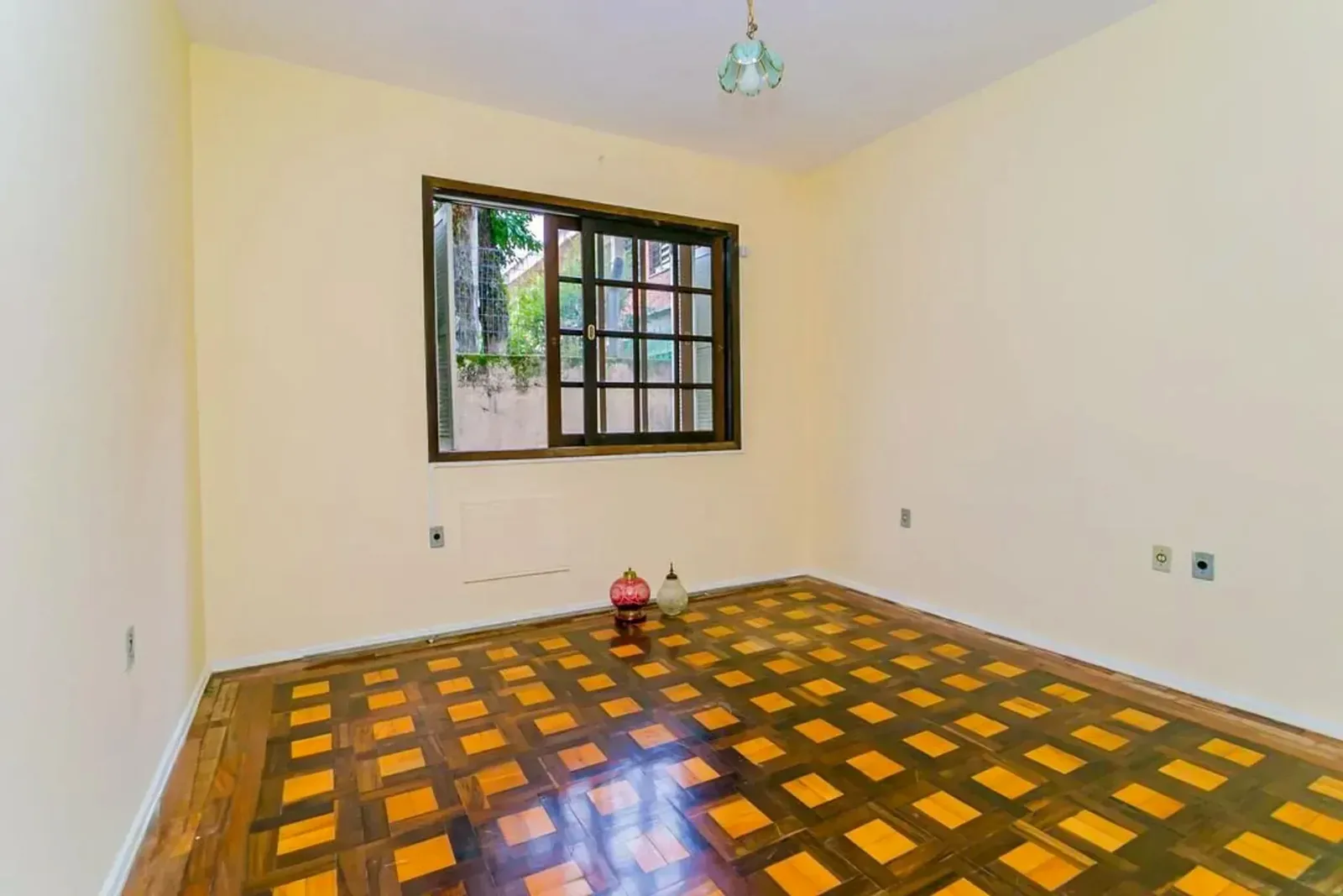 Dormitório com janela e piso de parquet