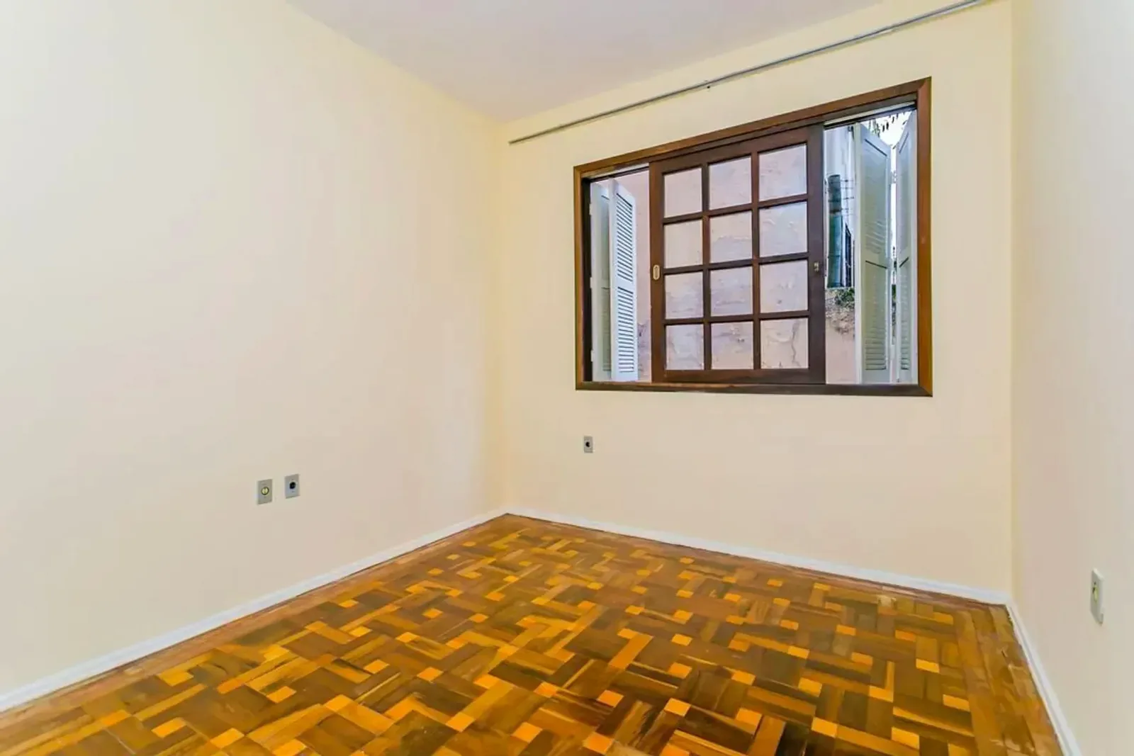 Dormitório amplo com janela de madeira
