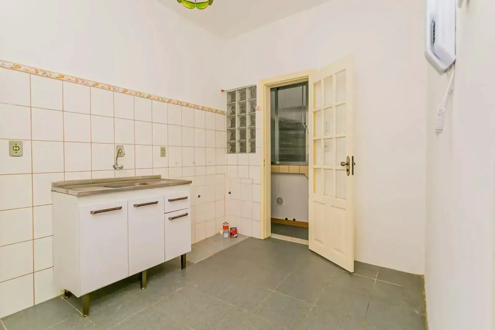Cozinha com azulejos e porta para a área de serviço