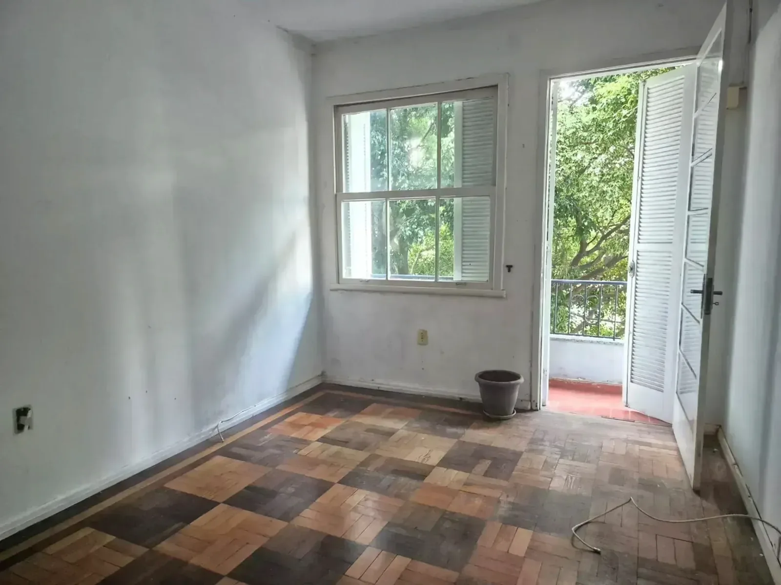 Dormitório com janela para as árvores e porta para a sacada