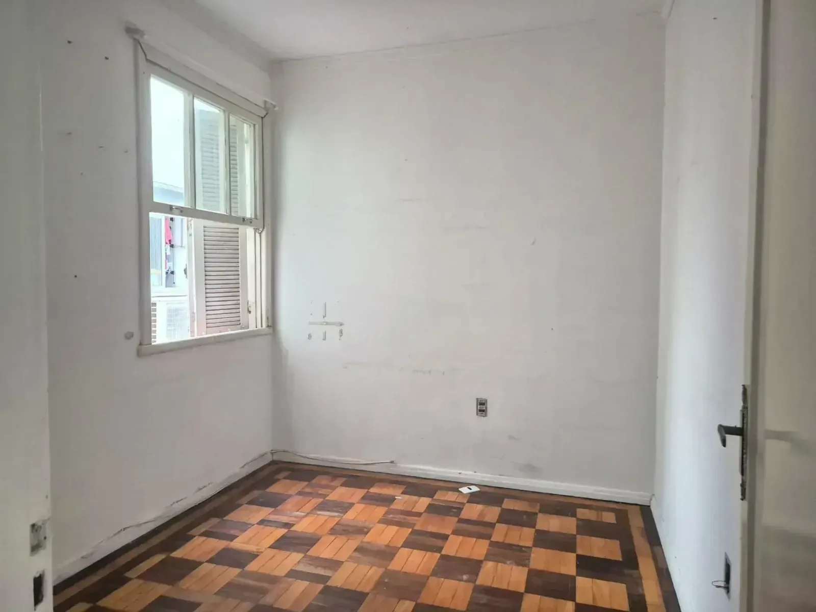 Dormitório com janela e piso de parquet
