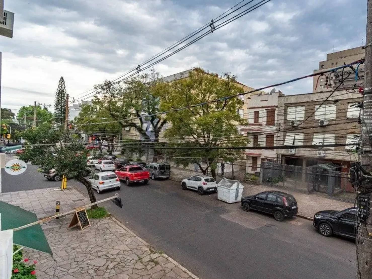 Rua arborizada em frente ao prédio