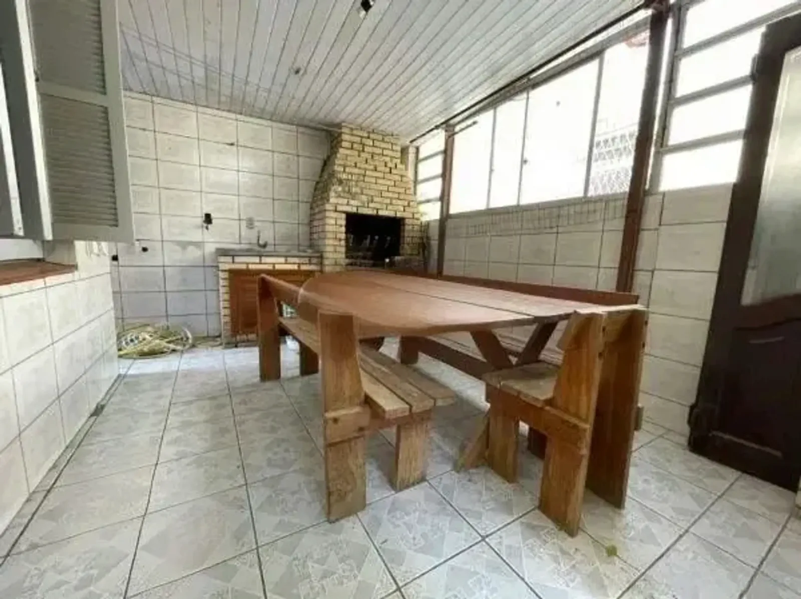 Espaço com churrasqueira e mesa grande