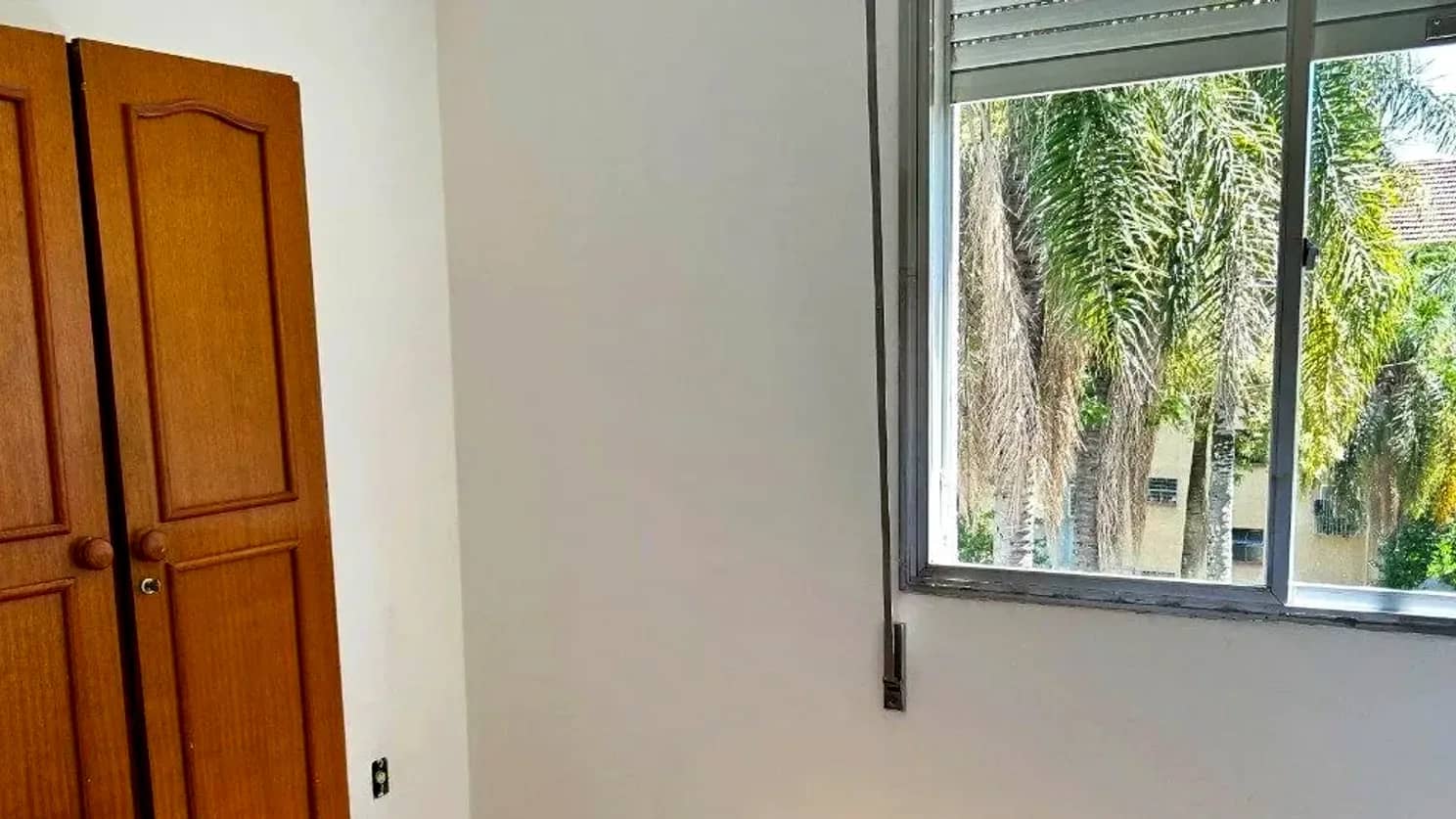 Dormitório com armário e janela para as árvores