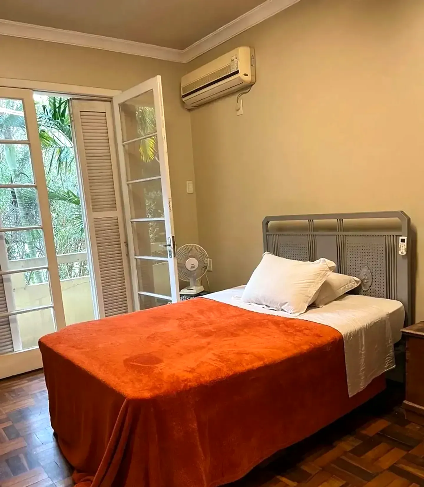 Dormitório com porta-janela e ar-condicionado
