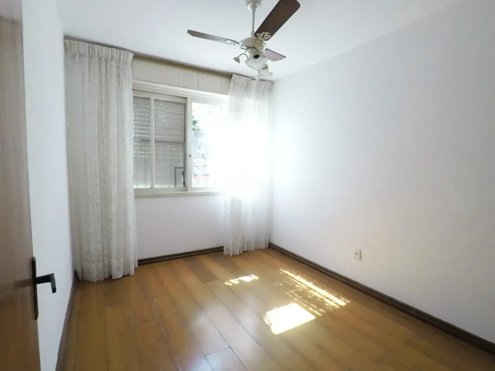 Dormitório com janela e piso de madeira