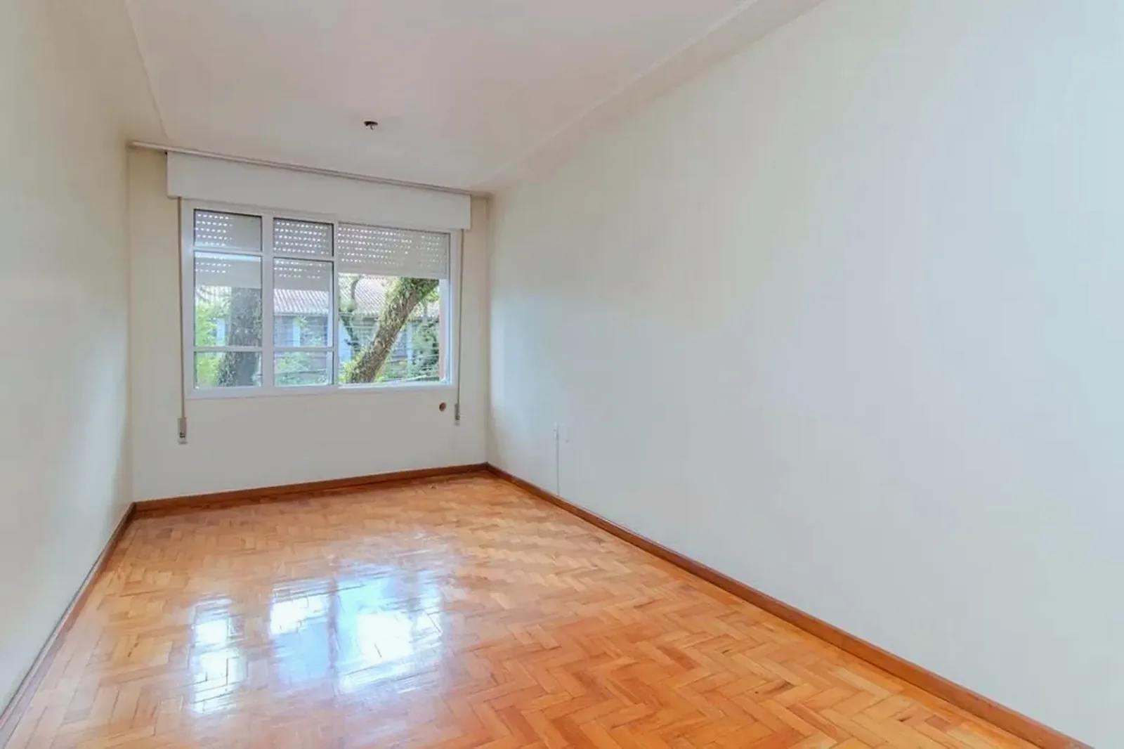 Living com janela para a rua arborizada