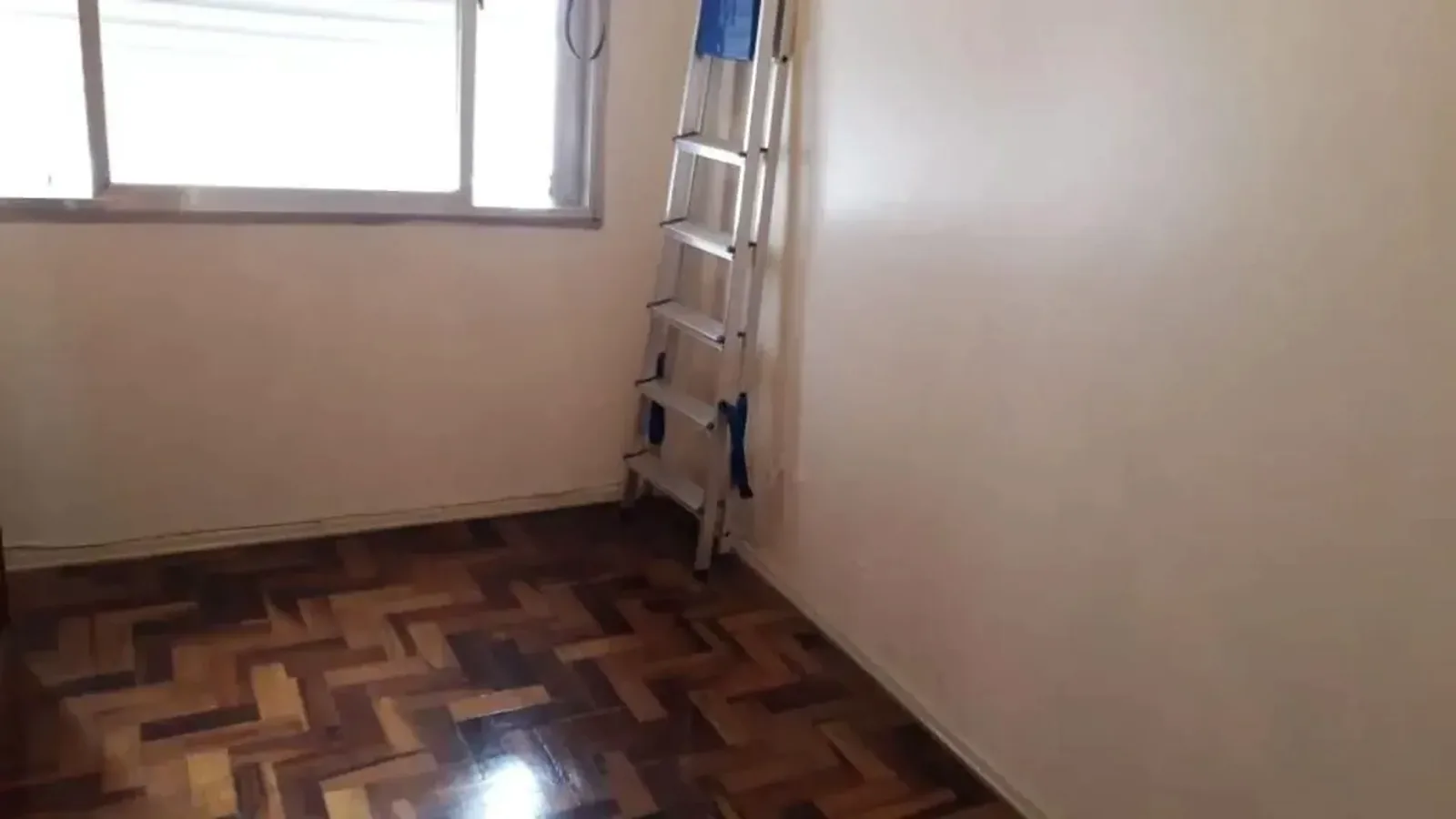 Quarto com janela ampla e parquet