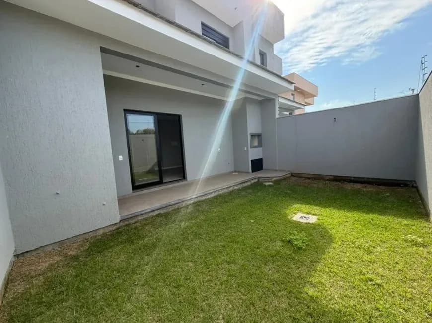 Área coberta dos fundos com porta de vidro de correr e gramado ao lado