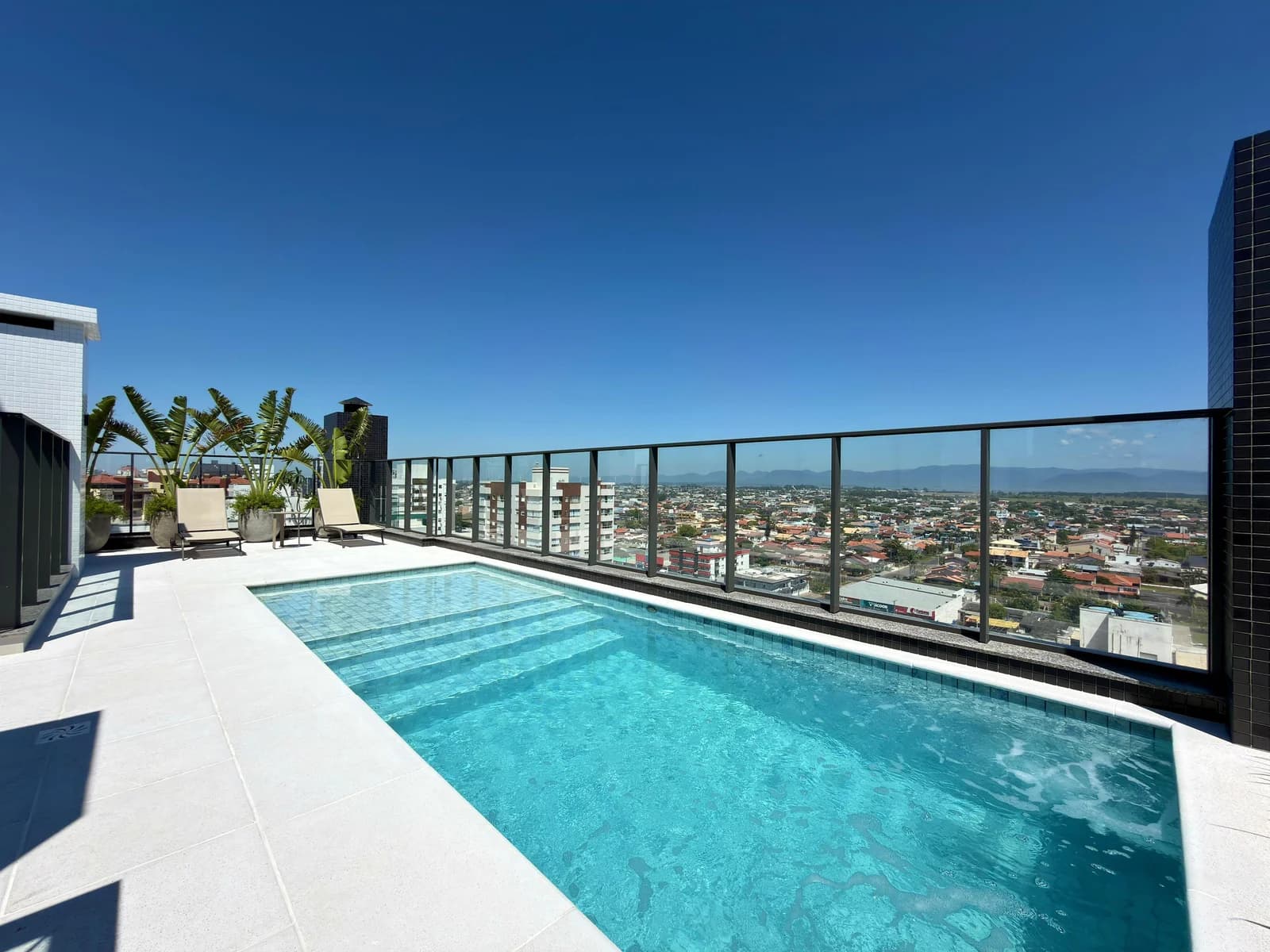 Piscina do terraço do Bel Giardino Residencial, com vista para a cidade e as montanhas.