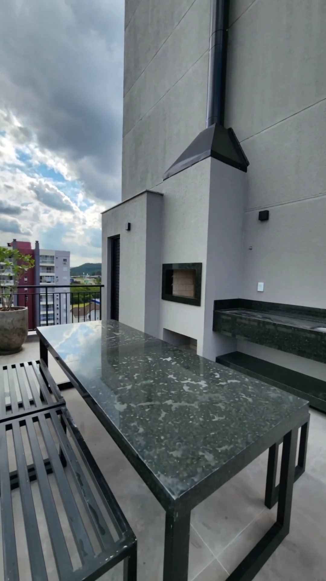 Terraço Fire, com cadeiras de madeira e lareira externa