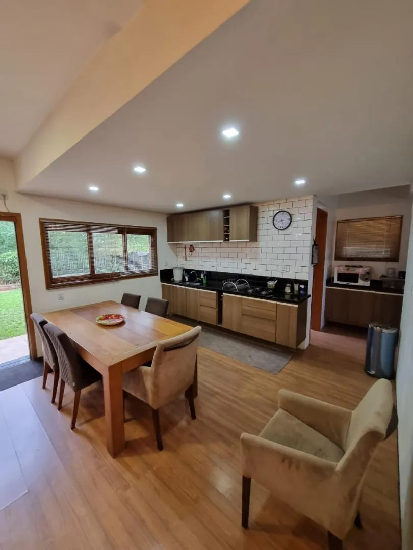 Cozinha e sala de jantar integradas, com janelas para o gramado.