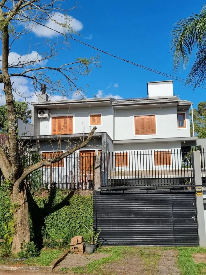Fachada dos três pavimentos, com sacada de madeira e céu aberto.