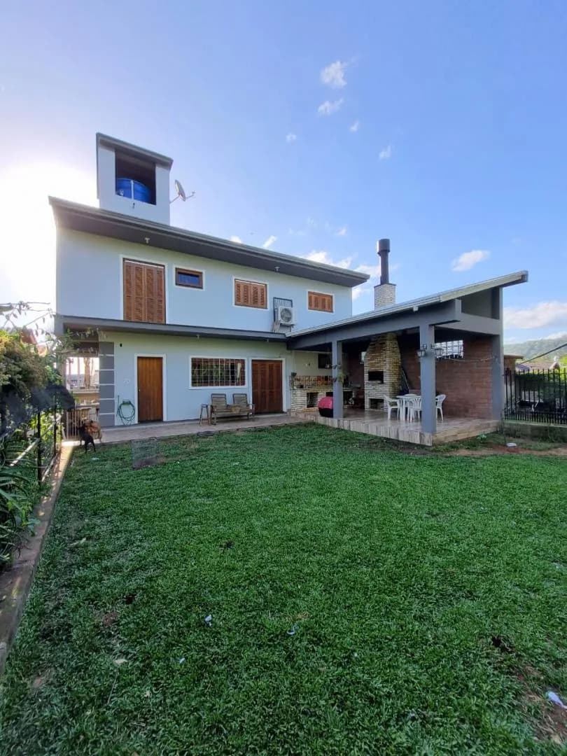 Os 120 m² de gramado nos fundos, com a casa ao fundo.
