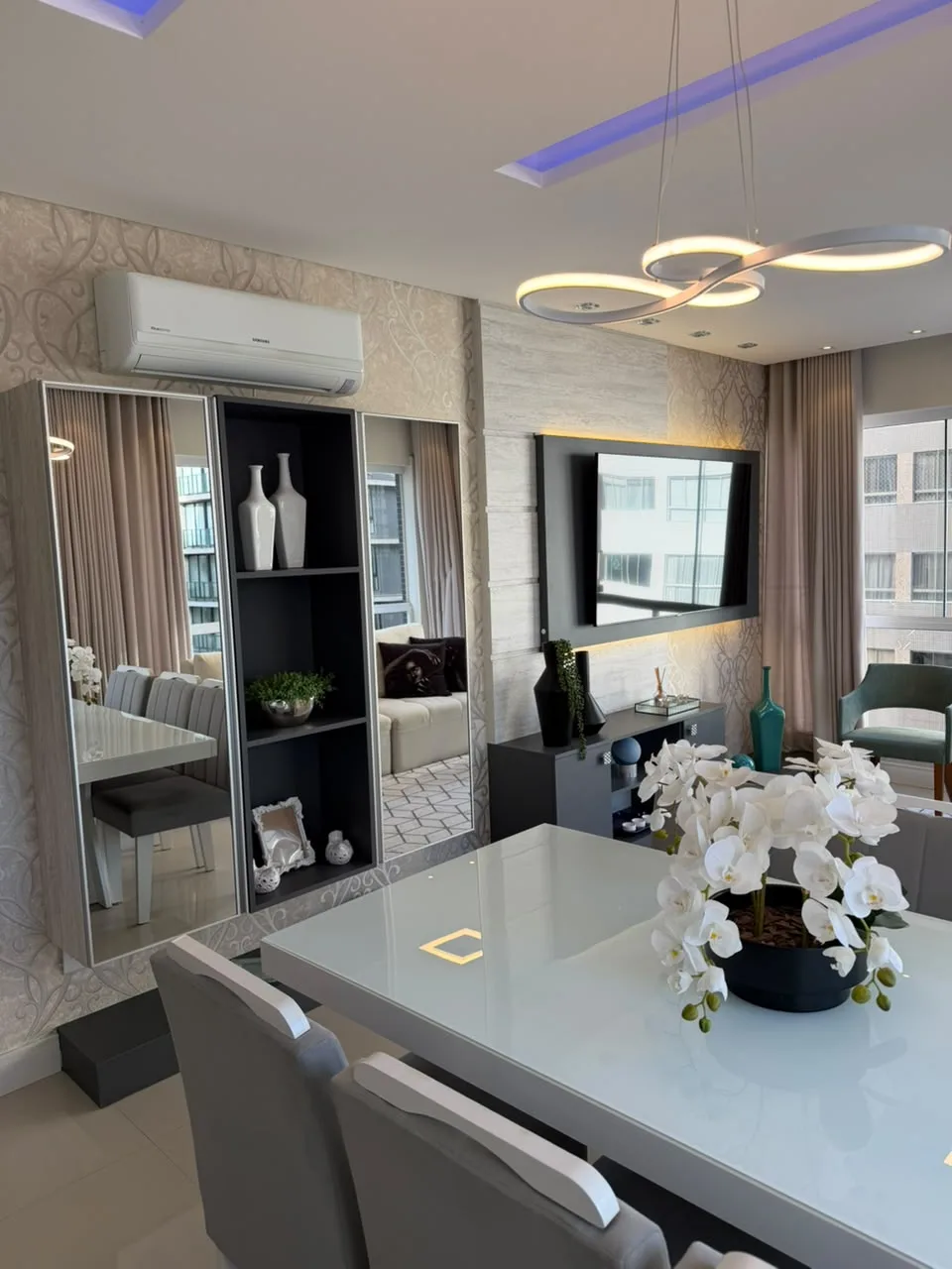 Sala de jantar com mesa branca e cadeiras estofadas