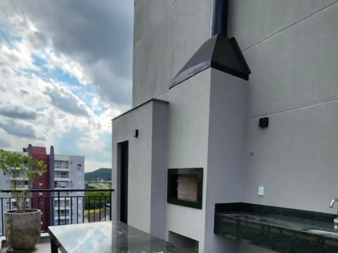 Terraço do Campus Studios II, com lareira, churrasqueira e vista para a cidade.