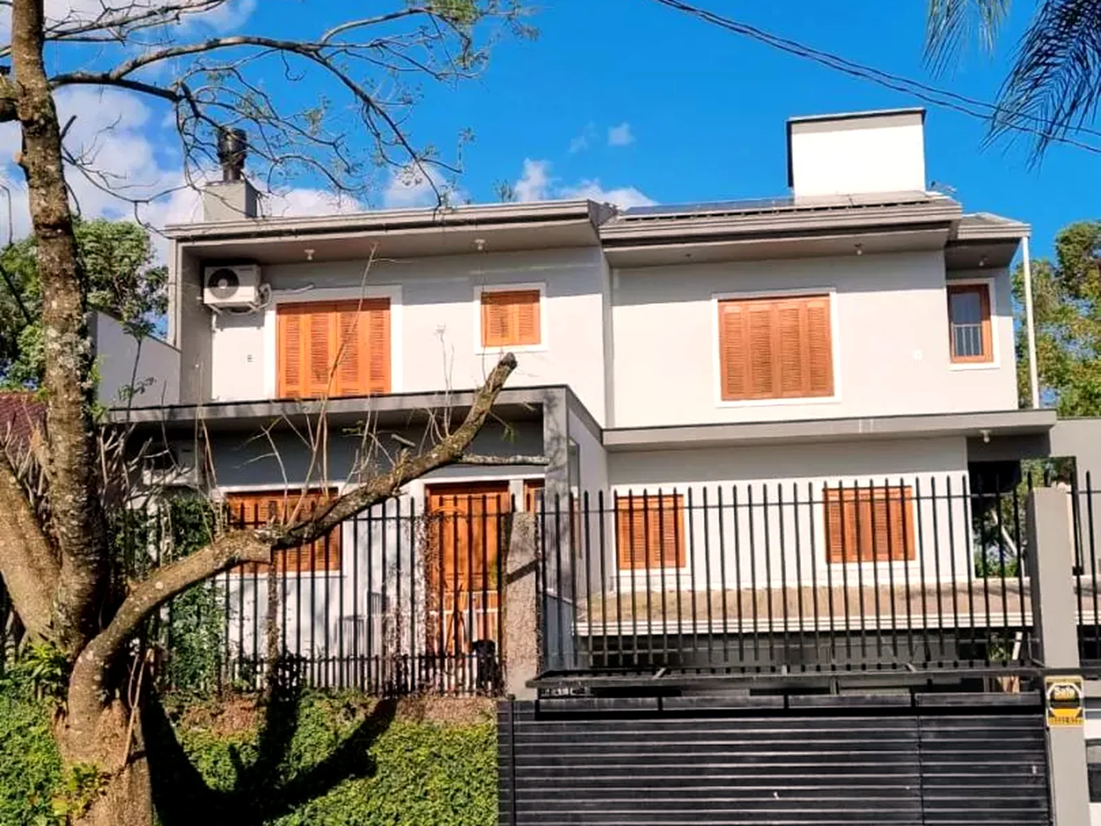 Fachada dos três pavimentos, com sacada de madeira e céu aberto.