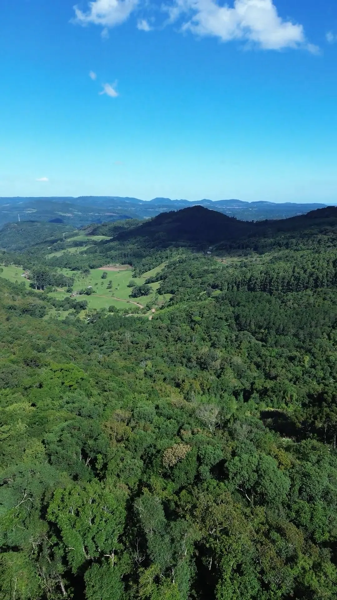 Vista ampla do vale, da mata e do céu aberto sobre a serra.