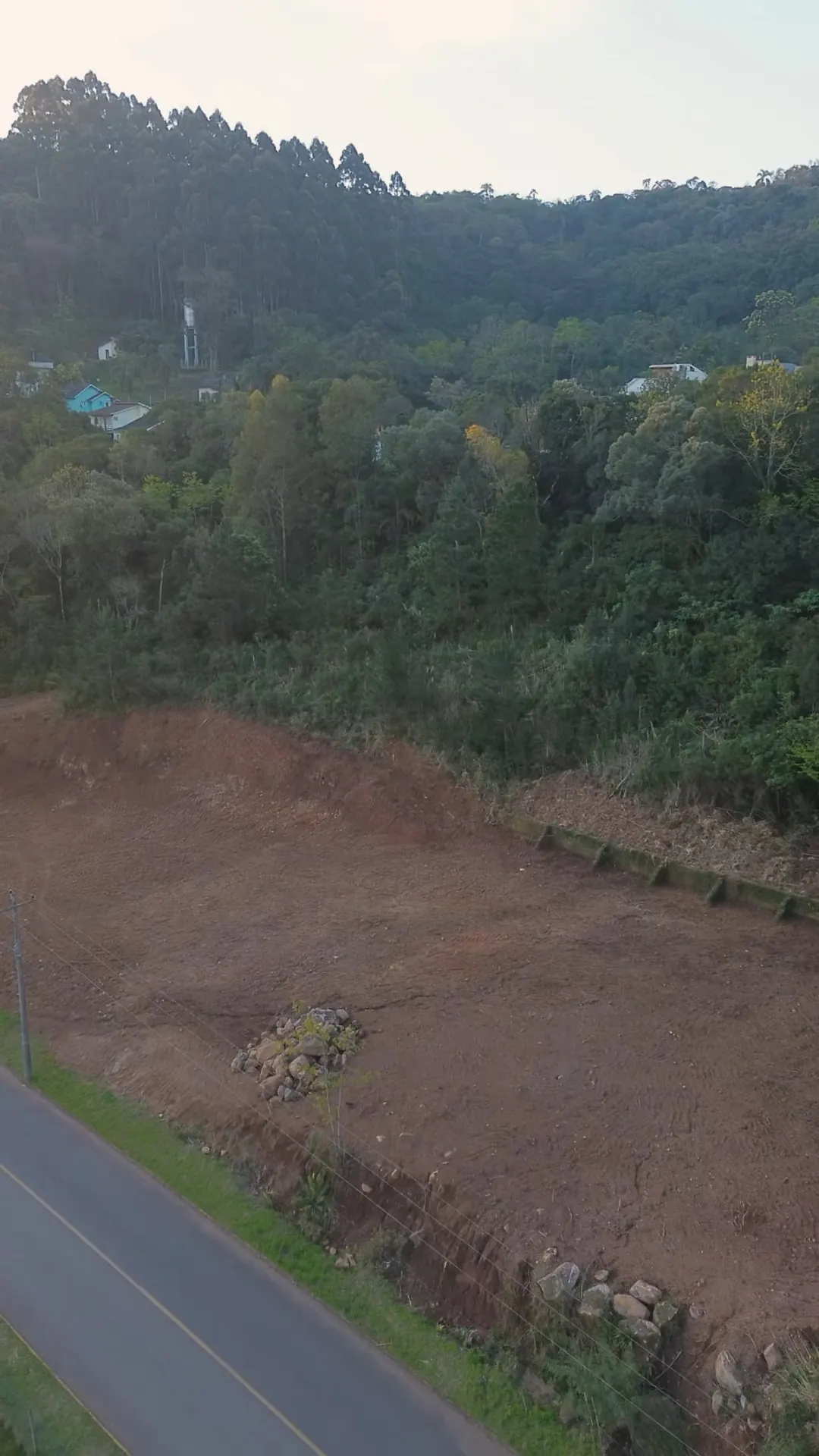 A área limpa do terreno, com a mata e o morro ao fundo.