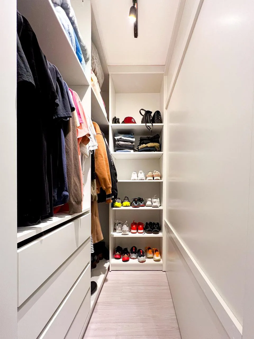 Closet, com araras, prateleiras e sapateira organizados.
