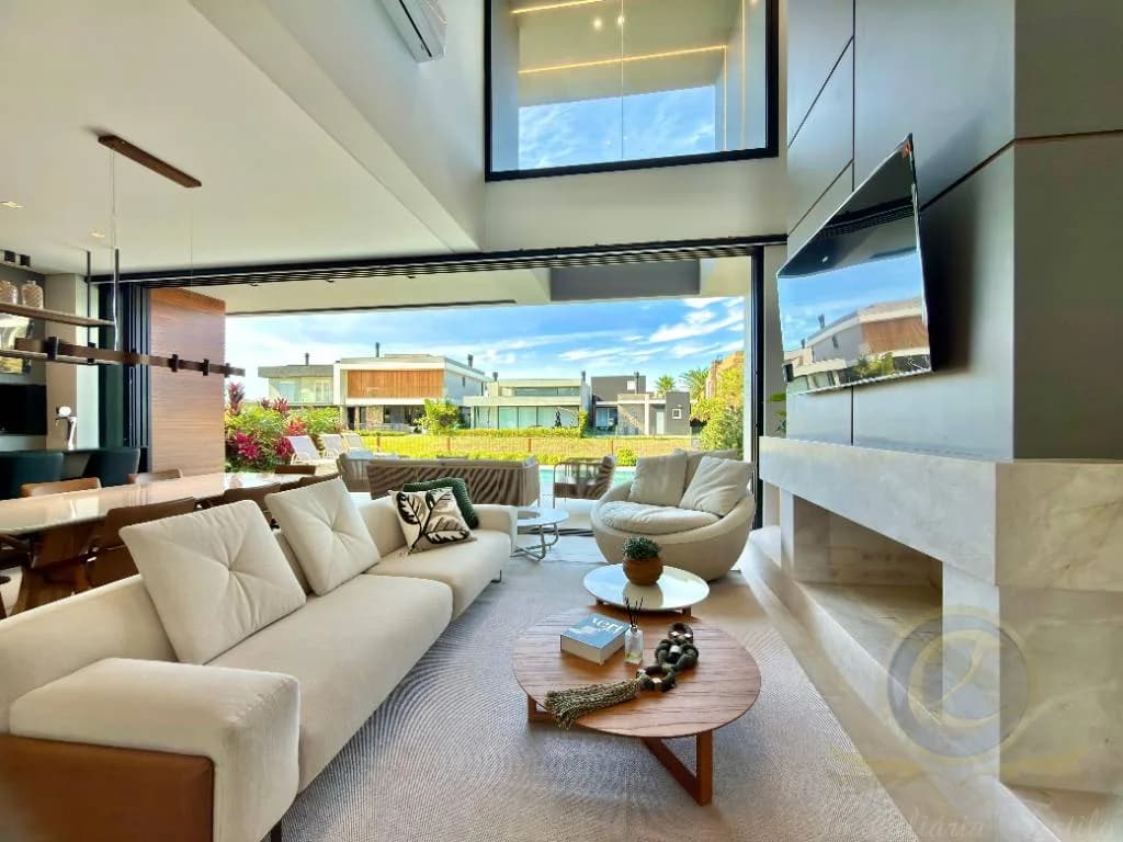 Living amplo com vista para a piscina através de vidro, casa à venda no condomínio Capão Ilhas, ref. 24354.