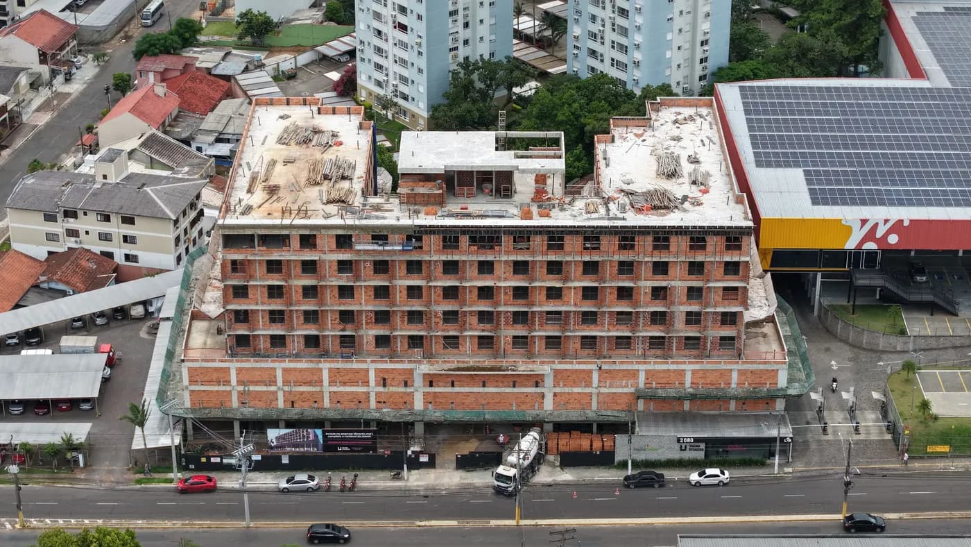 Foto real da obra do Tecno Studios, outro ângulo aéreo mostrando o canteiro e a estrutura em construção.